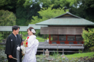 白鳥庭園で和装前撮り　蘭の髪飾りを付けた花嫁と花婿が見つめ合う