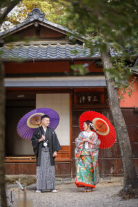 揚輝荘で和装ウェディングフォト　和傘を持ち微笑む新郎新婦　落ち着いた空間で撮影