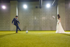 豊田スタジアムでウェディングドレス前撮り　ウォームアップ室でボールを蹴る新郎新婦