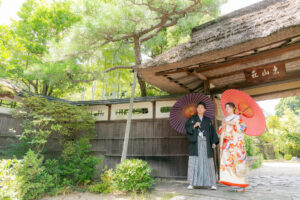 東山荘で和装ウェディングフォト　門の前で遠くを見つめる新郎新婦　和傘を使った写真
