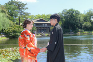 徳川園で和装ウェディングフォト　大きな池の前で手を取り合う新郎新婦　和装が映えるロケ地