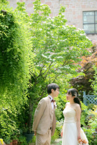久屋大通庭園フラリエで洋装フォトウェディング　緑をバックに見つめ合う新郎新婦　都会にある自然の中で前撮り