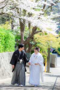 揚輝荘周辺で和装ウェディングフォト　桜が咲く道を歩く新郎新婦　名古屋でロケーション前撮り
