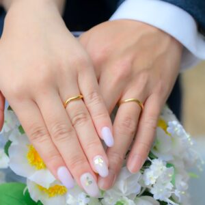久屋大通庭園フラリエで洋装ロケーション前撮り　ブーケの上に手を重ねる新郎新婦　結婚指輪　花嫁ネイル