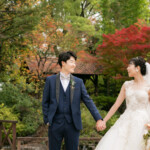 フラリエで前撮りウェディングフォト・紅葉を背景に手をつなぐ新郎新婦