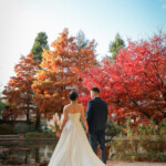 紅葉のフラリエで前撮りロケーション 池のそばで立つ新郎新婦